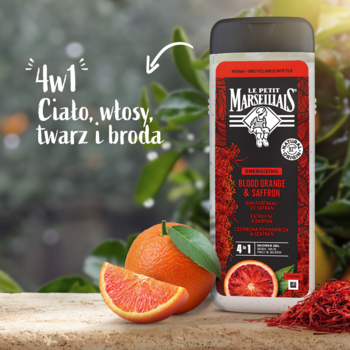 Le Petit Marseillais żel 4w1 Czerwona Pomarańcza i Szafran w czarnej butelce, obok pomarańcza i szafran, zielone tło.