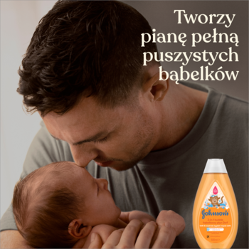 Ojciec czule całuje główkę niemowlęcia, obok pomarańczowy Johnson’s Baby płyn 2w1 do kąpieli, z kaczuszką, hipoalergiczny.