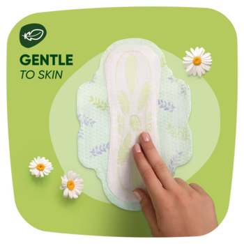 Podpaska Naturella Ultra Normal Camomile, biała z zielonymi wzorami, dotykana dłonią, "GENTLE TO SKIN", na zielonym tle z rumiankami.