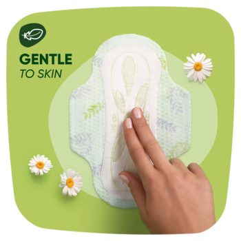 Biała podpaska Naturella Ultra z zielonym wzorem, dłoń dotyka powierzchni, zielone tło z logo "GENTLE TO SKIN".