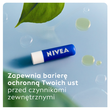 Zbliżenie niebieskiej pomadki ochronnej NIVEA Original Care z kropelkami wody i zielonym liściem na niebieskim tle.