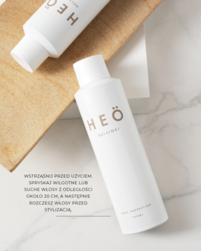 Widok z góry na biały spray termoochronny Heö Helsinki Heat Protection na marmurze z deską, obok druga butelka.