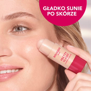 Kobieta aplikuje rozświetlacz Bourjois Pretty Glassy w sztyfcie na policzek, gładko sunący po skórze.
