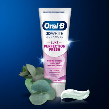 Frontalny widok tubki Oral-B 3D White Luxe Perfection Fresh, biała z różem, obok zielone liście i wyciśnięta pasta.