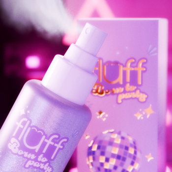 Fioletowa mgiełka z brokatem Fluff Born to Party, butelka spray, widoczne połyskujące drobinki, rozmyte pudełko.