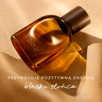 MEXX Inspired Glow męska woda perfumowana, bursztynowa butelka z drewnianym korkiem, leżąca na tle z ciepłym blaskiem.
