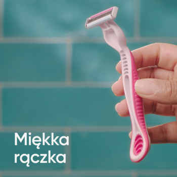Różowa maszynka jednorazowa Gillette Venus 3 Dragonfruit z miękką rączką, trzymana w dłoni na turkusowym tle.