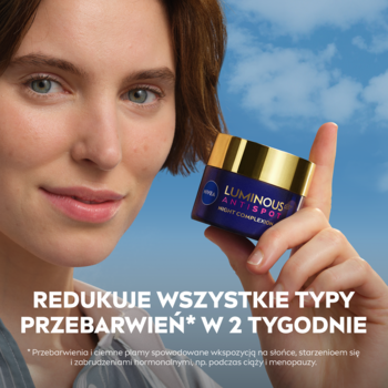 Młoda kobieta z kremem NIVEA LUMINOUS630 na noc, fioletowy słoiczek ze złotą zakrętką redukujący przebarwienia.