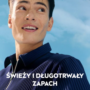 Uśmiechnięty mężczyzna w niebieskiej koszuli na tle błękitnego nieba. Napis: ŚWIEŻY I DŁUGO TRWAŁY ZAPACH.