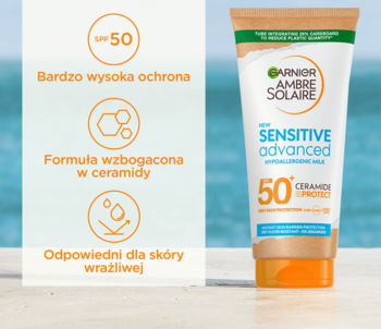 Garnier Ambre Solaire Sensitive Advanced SPF 50+ w białej tubie, z panelem cech: ceramidy, wysoka ochrona, skóra wrażliwa, na tle plaży.