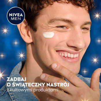 Uśmiechnięty mężczyzna aplikuje nawilżający krem NIVEA MEN na policzek, tło z świątecznymi gwiazdkami.