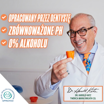 Dentysta Dr. Harold Katz uśmiecha się, trzymając pomarańczowy kubeczek płynu The Breath Co. z napisem 0% alkoholu.