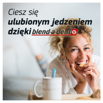 Radosna kobieta z kręconymi włosami je ciastko, ciesząc się posiłkiem dzięki klejowi do protez Blend-a-dent.