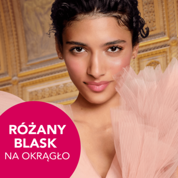 Bourjois róż: uśmiechnięta kobieta z subtelnym różanym blaskiem na policzkach, na tle złotej ściany.