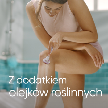 Kobieta goli nogę maszynką Gillette Venus Comfortglide Breeze, z paskami żelowymi z olejkami roślinnymi.
