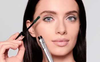 Kobieta aplikuje zielony tusz Pupa Mascara Vamp! Military Green na rzęsy, ukazując efekt sztucznych rzęs.