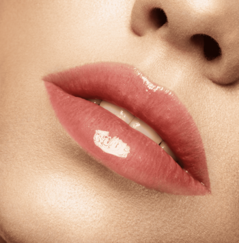 Zbliżenie na usta z J.Cat Beauty balsamem Full Gleam, różowo-koralowy kolor, lustrzany blask, pełniejsze usta.
