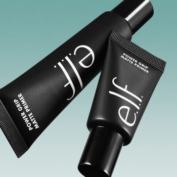 Zbliżenie na dwie czarne tubki matującej bazy e.l.f. Power Grip Matte Primer, ukośnie na turkusowym tle.