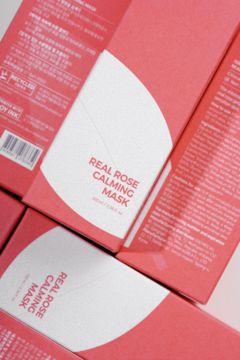Zbliżenie z góry na kilka różowych pudełek Isntree Real Rose Calming Mask z różą damasceńską.