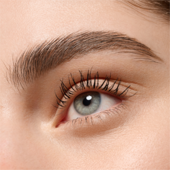 Zbliżenie na jasnoszare oko z długimi, podkreślonymi rzęsami. Naturalna, gęsta brew i gładka skóra.
