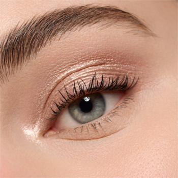 Zbliżenie na kobiece oko z niebiesko-szarą tęczówką, naturalny makijaż z subtelnym cieniem i tuszem na rzęsach.