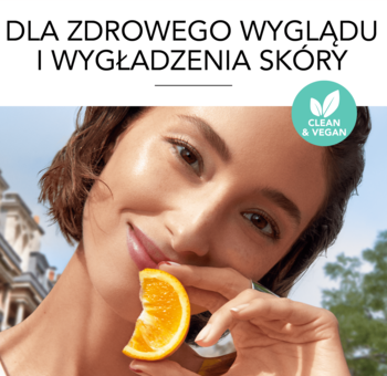 Kobieta z gładką cerą trzyma buteleczkę bazy Bourjois Healthy Mix Clean i plaster pomarańczy. Clean & Vegan.