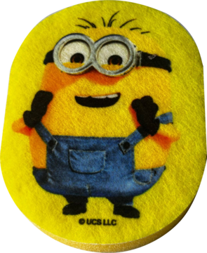 Żółta gąbka kąpielowa dla dzieci, okrągła, z motywem Minionka w niebieskich ogrodniczkach. Miękki poliuretan.