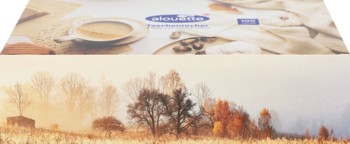 Górna część: filiżanka kawy, ziarna i niewyraźne opakowanie chusteczek higienicznych 100 szt. na beżowym blacie. Dolna: mglisty krajobraz z drzewami.