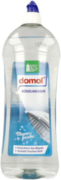 Przezroczysta butelka Domol Woda do prasowania Morska Świeżość, z przodu, niebieska etykieta z żelazkiem.