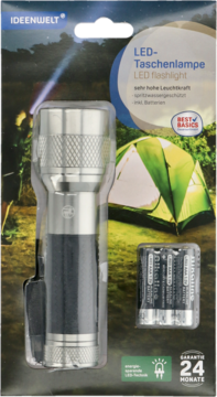 Srebrno-czarna latarka LED ideenwelt w opakowaniu detalicznym z bateriami AAA, na tle namiotu, widok z przodu.