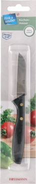 Nóż kuchenny Rossmann z czarną rękojeścią, „extra scharf!”, w blistrze, na tle świeżych warzyw.