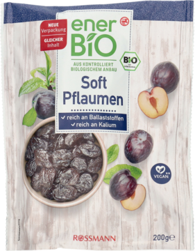 Biała paczka enerBiO Soft Pflaumen, suszonych śliwek bogatych w błonnik, z miską owoców na drewnie.