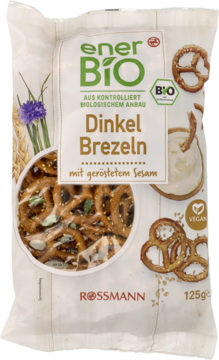 EnerBiO Dinkel Brezeln z prażonym sezamem. Biała torebka z preclami i miseczką dipu, widok z przodu.