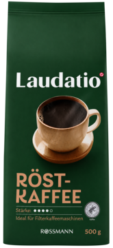 Laudatio Röst-Kaffee, ciemnozielona paczka kawy mielonej Rossmann 500g, z parującą filiżanką kawy, widok z przodu.