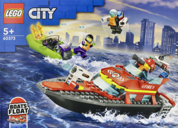 Pudełko LEGO City 60373: czerwona łódź ratunkowa i zielona motorówka z minifigurkami, pływające na wodzie.