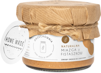 Naturalna miazga z fistaszków 'Home Made' w szklanym słoiku, z papierową pokrywką i etykietą, widok z przodu.