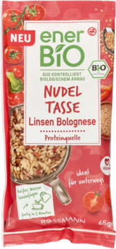 Czerwona paczka enerBiO Nudel Tasse Linsen Bolognese 65g, z makaronem w patelni i pomidorami, widok z przodu.