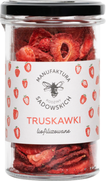 Czerwone, liofilizowane truskawki Manufaktura Rodziny Sadowskich w szklanym słoiku z czarną nakrętką, widok z przodu.