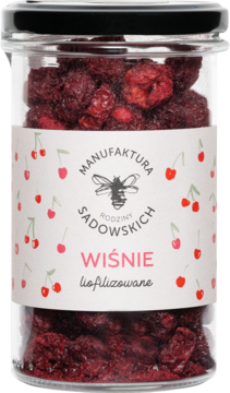Liofilizowane wiśnie Manufaktura Sadowskich w szklanym słoiku. Ciemnoczerwone, chrupiąca przekąska, biała etykieta, widok z przodu.