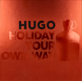 Reklamowe zdjęcie Hugo Man: pomarańczowe tło z wytłaczanym napisem "HUGO HOLIDAY YOUR OWN WAY" i butelką.