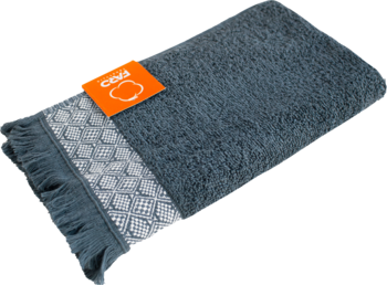 Ręcznik bawełniany popielaty 30x50 cm (500g/m²), złożony, z ozdobnym wzorem, frędzlami i pomarańczową metką.