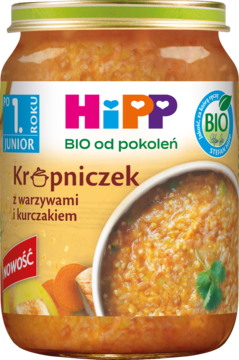HiPP Junior Krupniczek, słoiczek zupki z warzywami i kurczakiem, widok z przodu, z miską i marchewką.