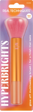 Real Techniques Glow Off Multitasking Brush w blistrze, z różowymi włóknami i pomarańczowym uchwytem.