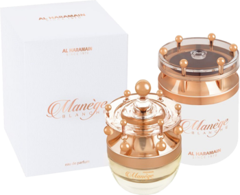 Dwa flakony i pudełka Manege Blanche Al Haramain Perfumes. Na pierwszym planie kremowy flakon z różowo-złotą, koronkową zakrętką.