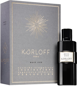 Korloff Paris Rose Oud, czarna butelka perfum obok szarego pudełka ze złotym słońcem i napisem.