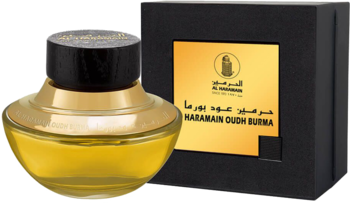 Złoty flakon Al Haramain Oudh Burma z czarną nakrętką, na tle czarnego pudełka z logo marki.