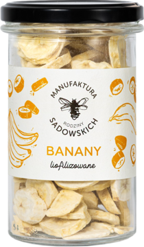 Banany liofilizowane Manufaktury Rodziny Sadowskich w szklanym słoiku, widoczne jasne plasterki, z przodu.
