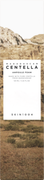 Pionowe opakowanie pianki Skin1004 Madagascar Centella Ampoule Foam, białe z tekstem, na tle brązowych wzgórz.