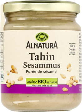 Słoik Alnatura Tahin, 100% bio kremowa pasta sezamowa, z przodu, ze złotą nakrętką i ziarnami sezamu.
