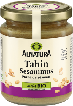 Frontalny widok słoika Alnatura Tahin Sesammus, bio pasta sezamowa, z biało-fioletową etykietą i złotą nakrętką.